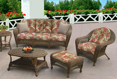 A wicker patio bench with a blue cushion