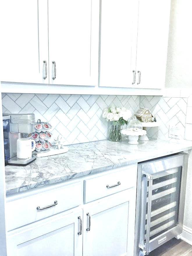 Classic white kitchen with ebony kitchen island with  turned legs topped with Princess White Quartzite lined