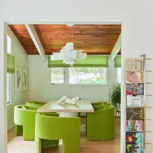 Earth tones like an olive green wall color and velvet chairs in rich ochre make this dining room designed by Bunny Williams a warm, inviting space to