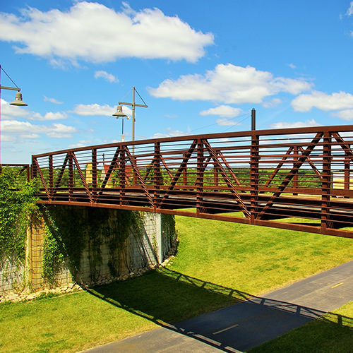 A Pony truss bridge locates the deck a bit above the middle of the truss  similar to the through truss, however this type of truss is designed for  lighter